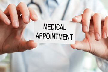 Doctor holding a card with text MEDICAL APPOINTMENT