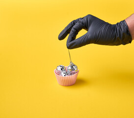 Muffin with disco balls and chef hand in black gloves. Nightlife in retro style. 
