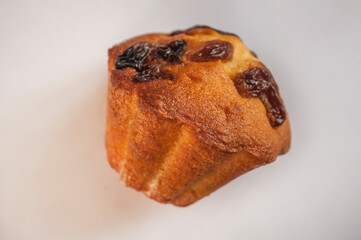 One cupcake with raisins on a light background, close-up photo