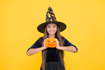 happy witch child with pumpkin jack o lantern wear costume of wizard on halloween party, halloween...