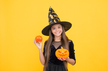happy witch kid with pumpkin jack o lantern wear costume of wizard on halloween party, halloween...