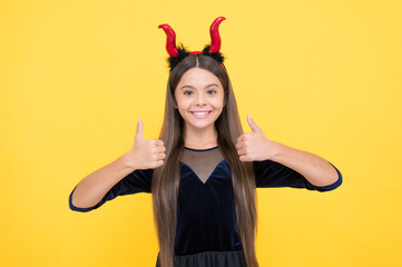 kid wear devil horns show thumb up. childhood autumn holiday. funny teen girl ready to celebrate...