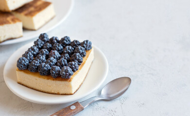 Delicious homemade cheesecake with blackberries on a light table. A curd casserole. Copy space.