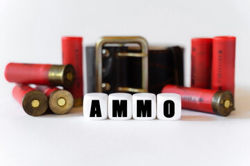 Against the background of cartridges and a military belt, cubes with the inscription - AMMO