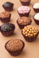 Typical brazilian brigadeiros, various flavors over wooden table, low depth of field