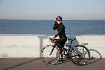 Fototapeta premium Portrait of female athlete cyclist. Outdoor cycling workout