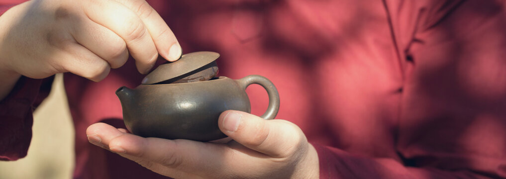 Ceramic bowls made of clay on a wooden background. .The man is drinking Chinese tea. - Powered by Adobe