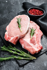 Raw pork loin steak. Organic meat. Black background. Top view