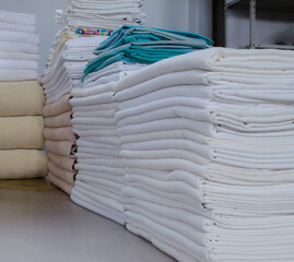 Stack of folded clean cloths in an industrial laundry.