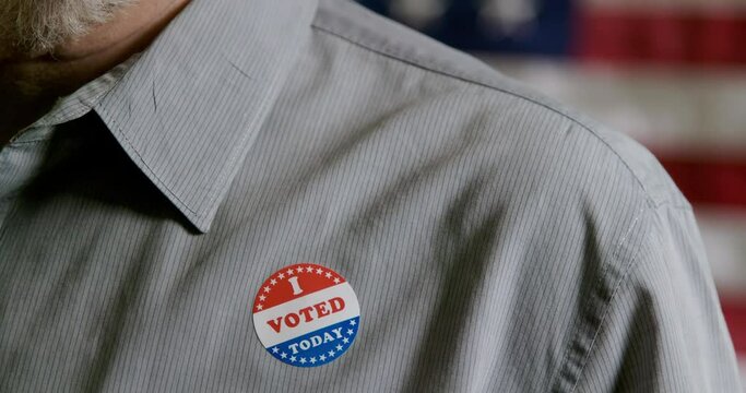 Closeup Of Man Putting A I Voted Sticker On His Shirt