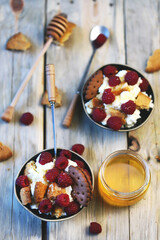 Mascarpone dessert with raspberries and biscuits in bowls.