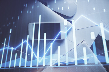 Multi exposure of forex graph hologram over desktop with phone. Top view. Mobile trade platform concept.