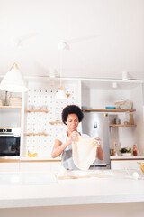 Woman holding rolled dough in kitchen