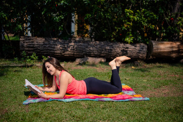 Woman reading a book while lying in the front yard