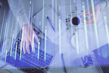 Multi exposure of man's hands typing over computer keyboard and forex graph hologram drawing. Top view. Financial markets concept.