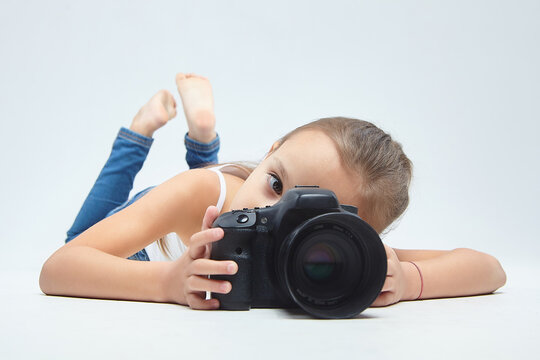 little girl with glasses, lying in the Studio with a camera