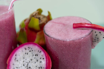 Pitaya juice and fruits on green background