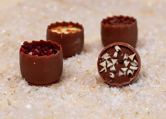 chocolates in the snow

Four chocolates lie on artificial snow in the middle, close-up side view.