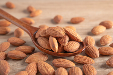 Almonds  seed on wooden spoon on table .