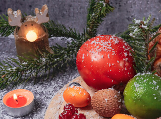 fruit and christmas decor
citrus and tropical fruits with christmas decor on dark stone background, close-up side view