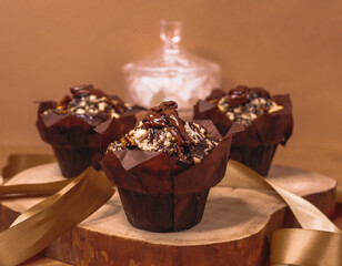chocolate muffins with nuts...

Chocolate muffins with nuts lie on a wooden frame, close-up side view.