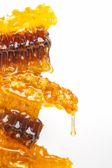 Drops of fresh honey dripping from a pyramid of wax honey. vitamin nutrition and bee product.