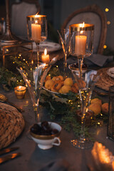 Christmas table with candles, flowers and fruits