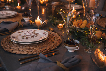 Christmas table with candles, flowers and fruits