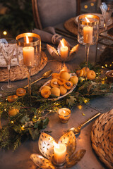 Christmas table with candles, flowers and fruits