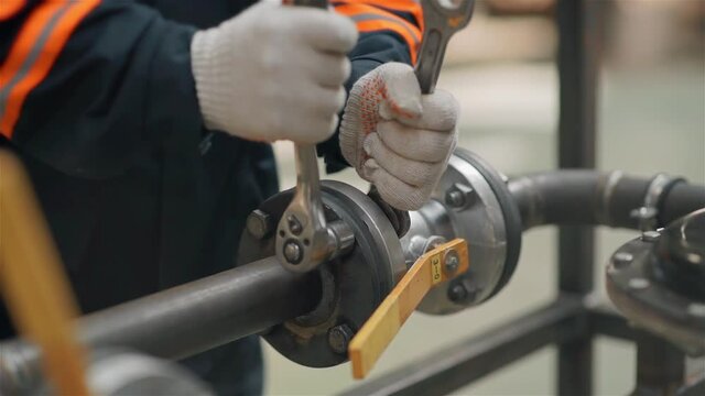 closeup of a hand with a wrench tighten the nut