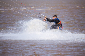 man splashed with water practicing kitesurfing
