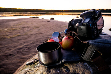 Camera, two apple, glasses and a mug of coffee.