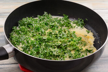Sauteed kale in cream sauce in non stick frying pan