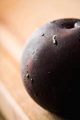 Freshly harvested red plum with condensation at cold autumn morning. Selective focus. Shallow depth of field.
