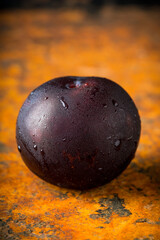 Freshly harvested red plum with condensation at cold autumn morning. Selective focus. Shallow depth of field.