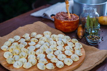 Dumplings and their ingredients on a dark wooden background.