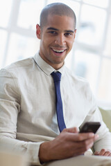 Fototapeta premium Portrait smiling young businessman using smart phone