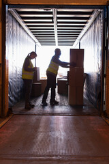Workers loading boxes into truck © Martin Barraud/Caia Image