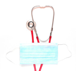 Medical red stethoscope and blue mask on white background. Copy space.