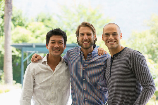 Portrait happy male friends on patio