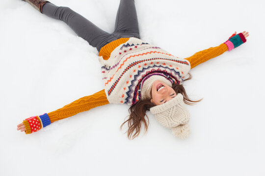 Carefree young woman making snow angel