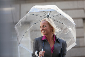 Smiling businesswoman with umbrella © Sam Edwards/Caia Image