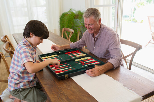 Grandfather and grandson playing backgammon