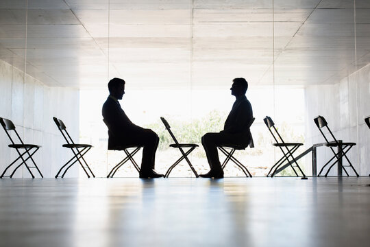 Silhouette businessmen sitting face to face