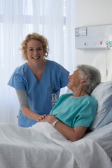Obraz premium Portrait happy female nurse caring for senior patient in hospital room