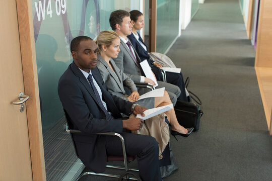 Business people waiting for job interview in office corridor