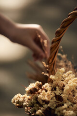A hand picks the flower in the basket
