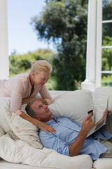 Obraz premium Senior couple online shopping with credit card and laptop on sofa