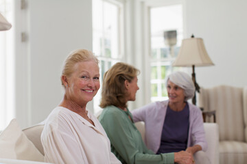 Fototapeta premium Portrait happy senior woman with friends in living room