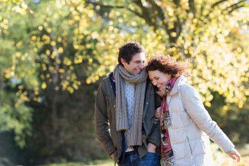 Fototapeta premium Happy affectionate young couple walking in autumn park